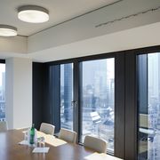 Zwei runde Deckenleuchten über Konferenztisch mit Blick auf Skyline bei Nordic Capital