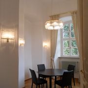 Elegante Deckenleuchte über rundem Tisch mit Stühlen im Schloss Untermerzbach
