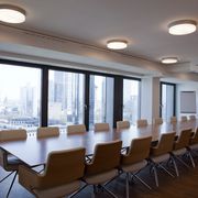 Runde Deckenleuchten über langem Konferenztisch mit Blick auf Skyline bei Nordic Capital