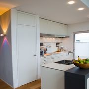 Lichtkonzept einer Küche mit Blick in den Flur und farblichen Lichtakzenten